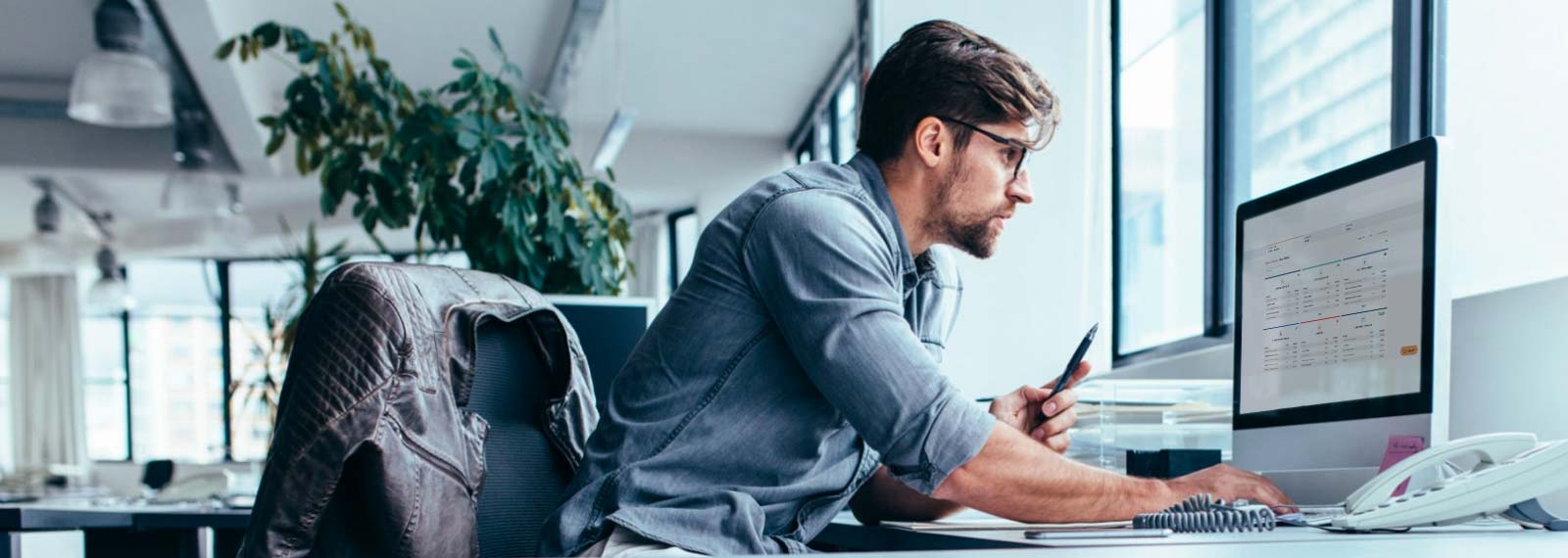 Man in office looking at overview of sales accounts with stats and analytics on computer
