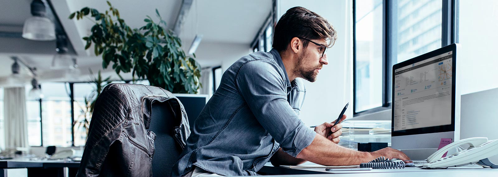 Man in office looking at overview of sales accounts with stats and analytics on computer