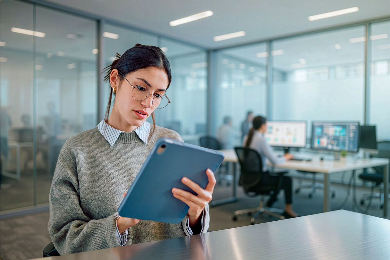 Woman in computer office looking at tablet