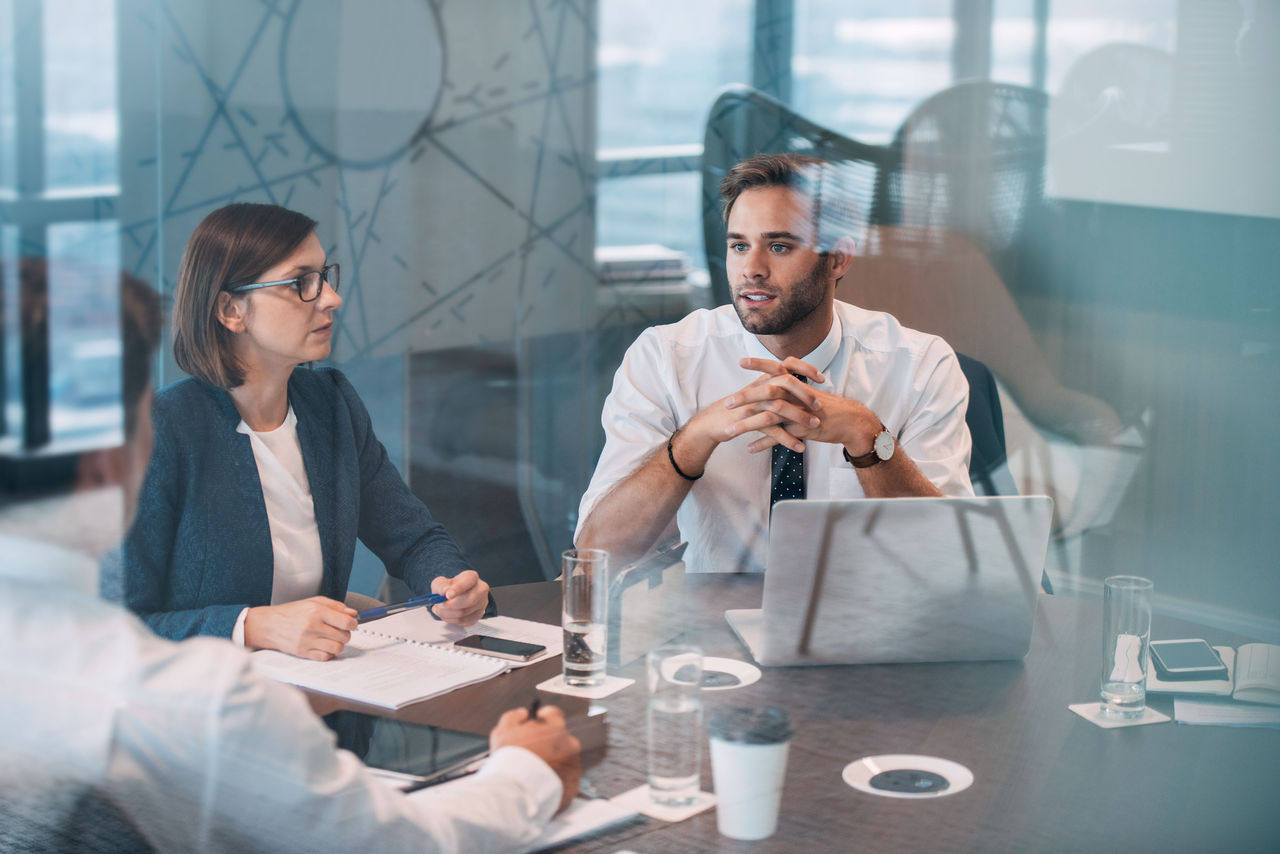 Group of successful businesspeople talking together while working around a table in an office boardroom