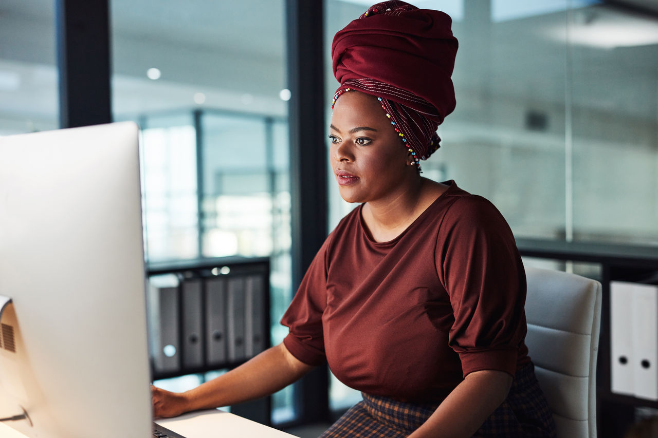 Woman with headscarf in office looking at computer
