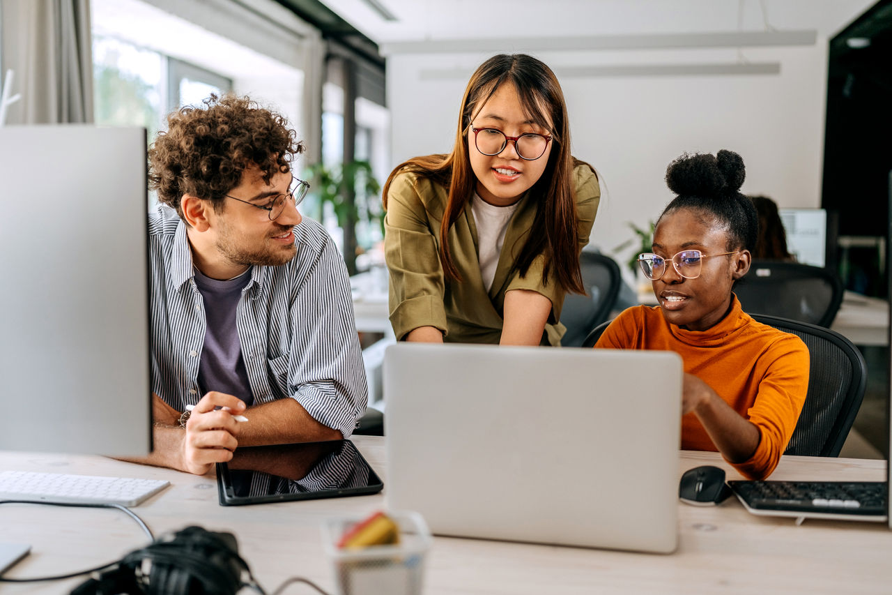 Three colleagues discussing work at an office