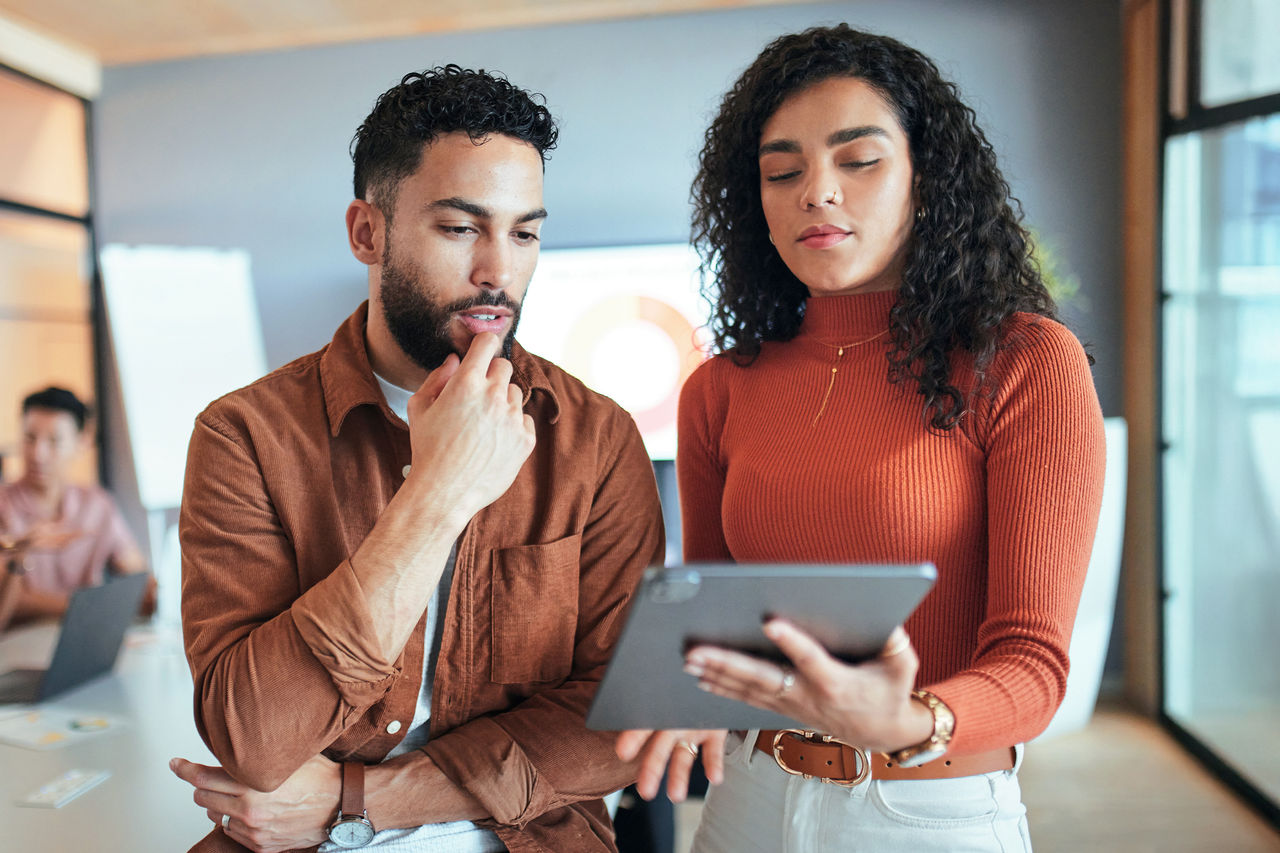 Two marketers looking at a tablet in an office, discussing IPPs.