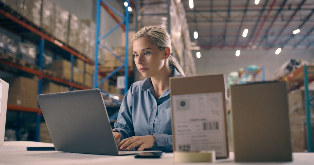 Business woman, laptop and box in supply chain, logistics or management in shipment control at warehouse