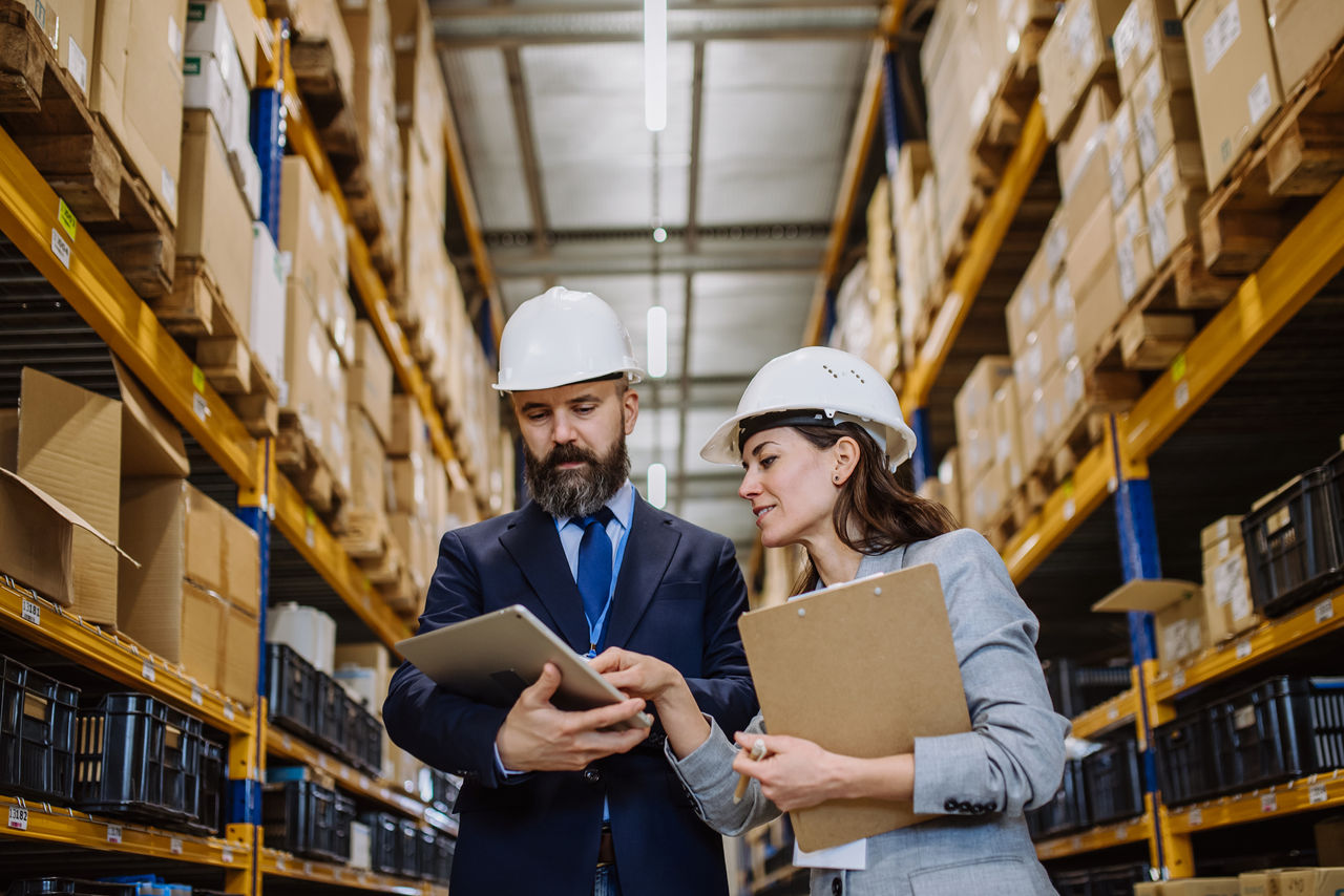 Two workers looking at tablet in warehouse