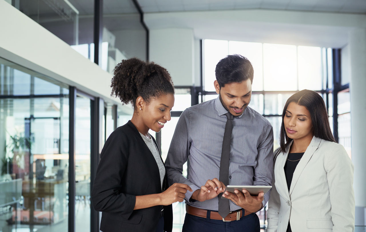 Shot of a group of businesspeople using a digital tablet together in an office