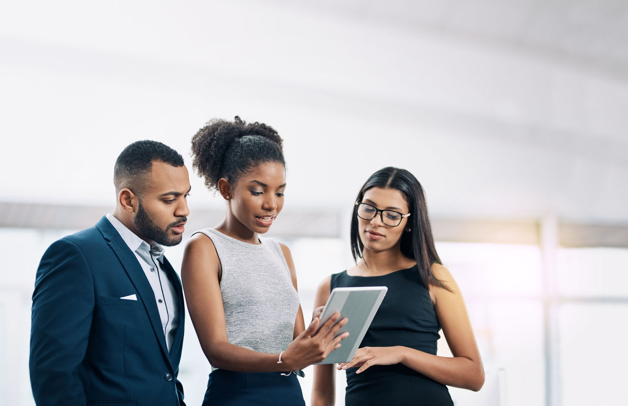 Shot of a business team using a digital tablet while having a meeting