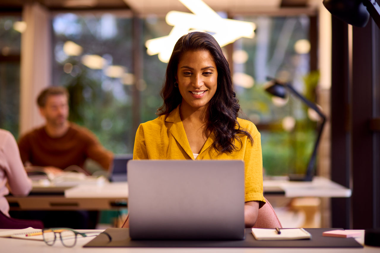 Businesswoman Working On Laptop At Desk In Office